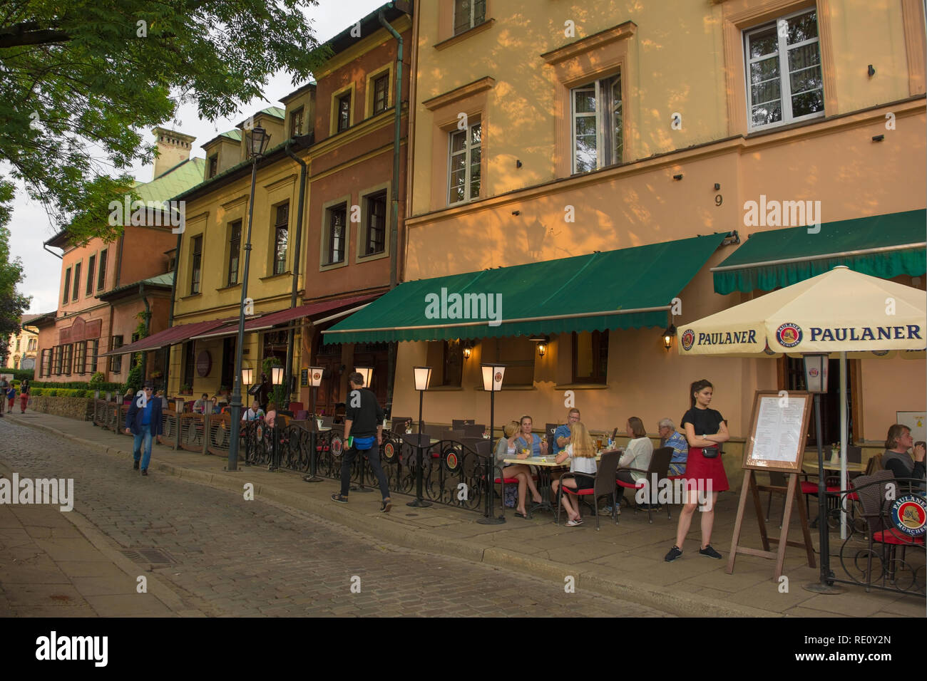 Krakow, Poland - July 9th 2018. A waitress waits for more customers outside a restaurant in the popular Krakow district of Kazimierz Stock Photo