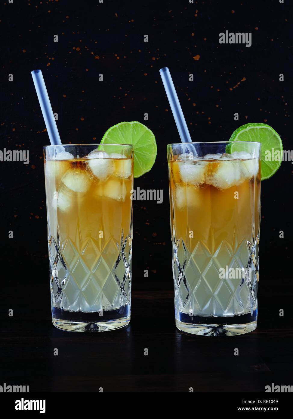 Dark 'n' stormy, a cocktail made using dark rum, ginger ale or beer, served in a highball glass filled with ice and garnished with a slice of lime Stock Photo