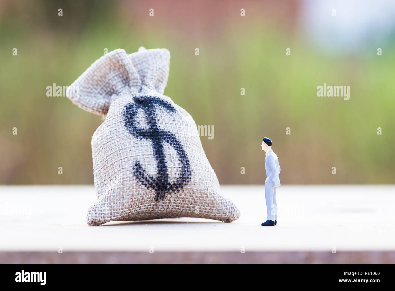Money investment. Savings money concepts. A figure man standing looking and thinking about what to do with this money. Growing money for business futu Stock Photo