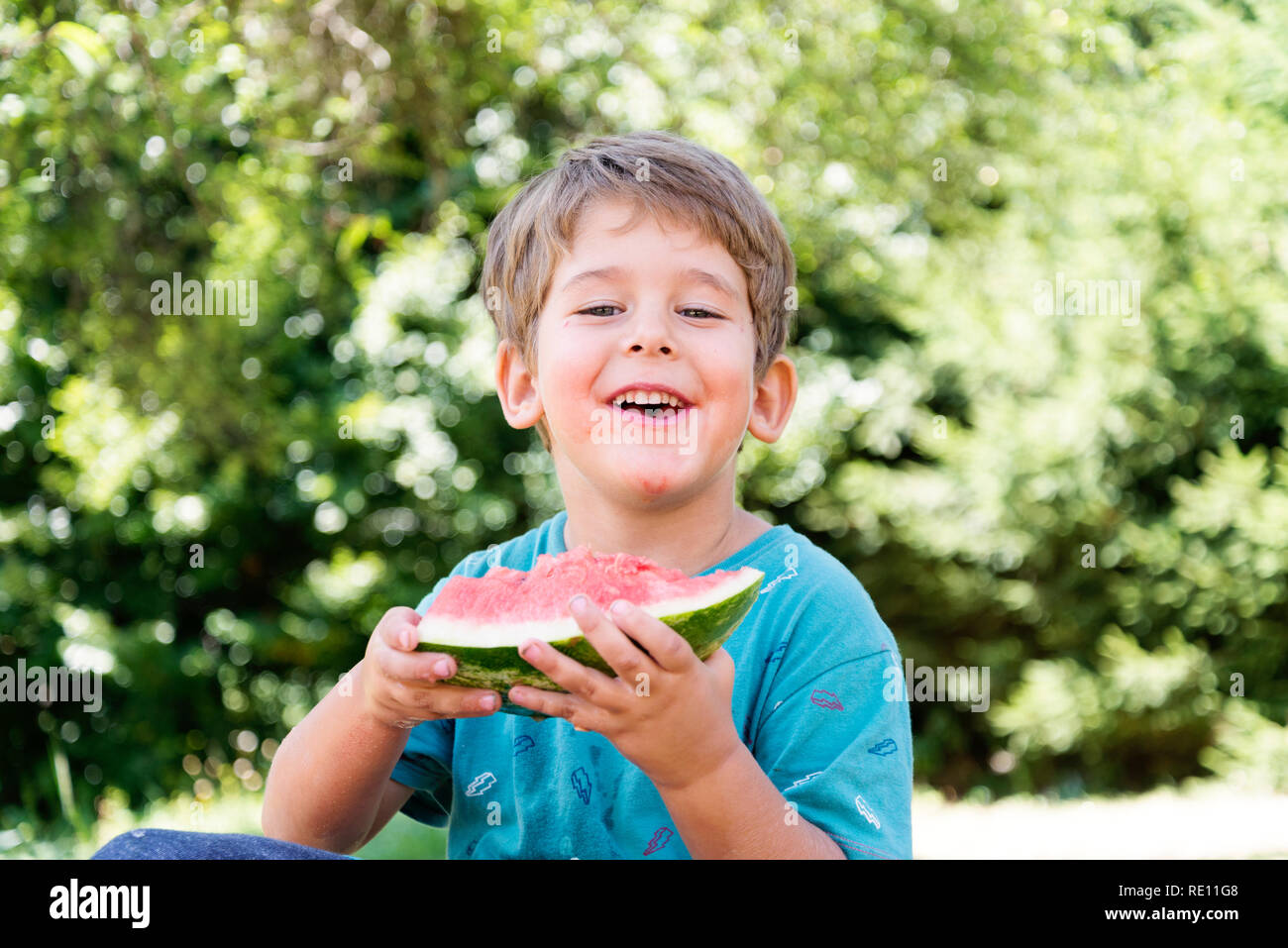 healthy eating concept, boy eating watermelon outdoors, vitamins and water for the summer Stock Photo