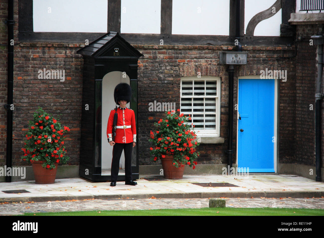 Grenadier Guard and sentry box in front of the Queen's House at Her Majesty's Royal Palace and Fortress of the Tower of London - London, UK Stock Photo