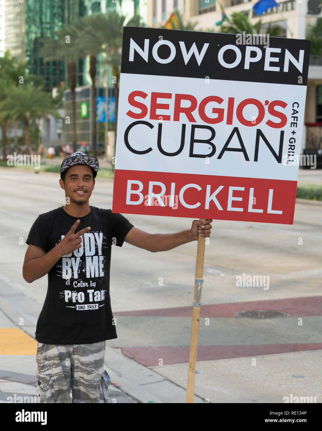 Man holding sign promoting the opening of a new Cuban restaurant in the Brickell District of downtown Miami, Florida Stock Photo