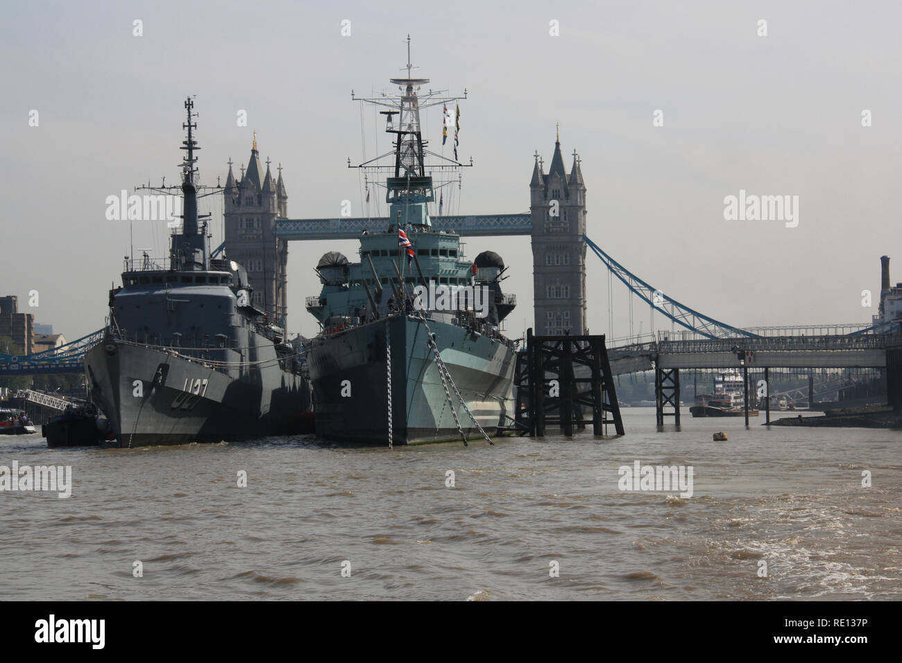 HMS Belfast and Brazilian training ship Brasil (U27) moored together at the Pool of London, United Kingdom, with the Tower Bridge in the background Stock Photo