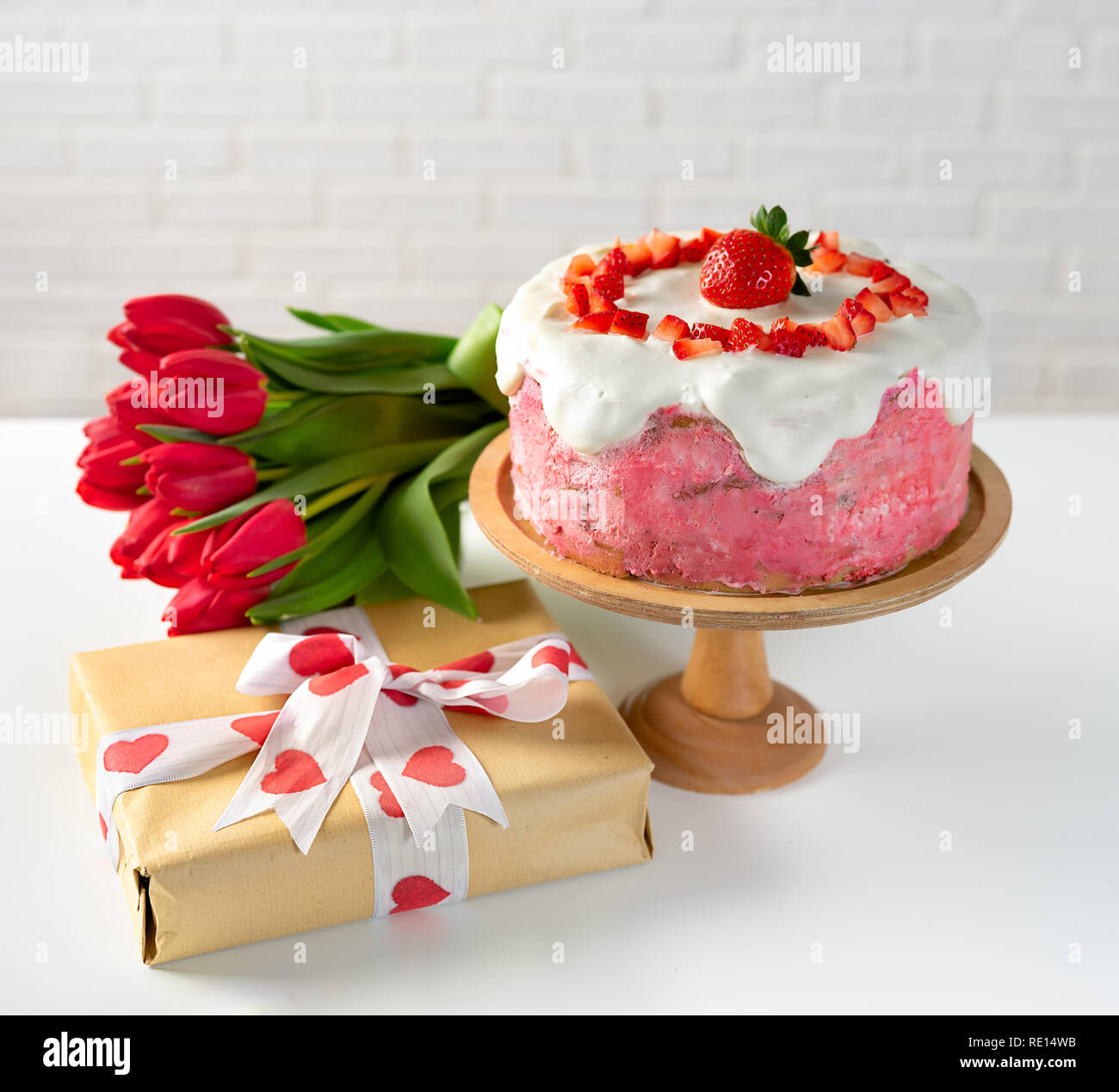 Strawberry cake with gift box and bunch of tulips Stock Photo
