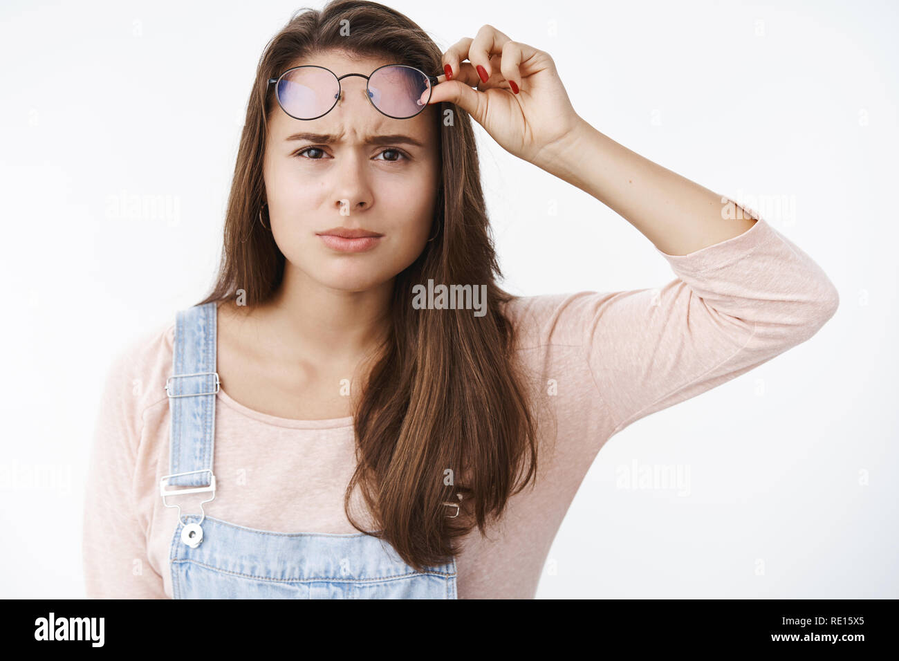Girl squinting and frowning as cannot read sign having bad sight taking
