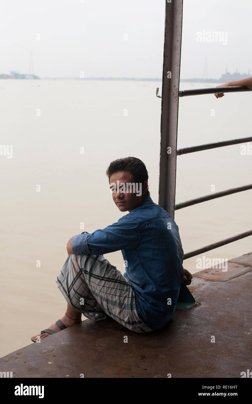 Kolkata / India - August 2015: A young man sitting on the ferry that connects Kolkata with Howrah. Stock Photo