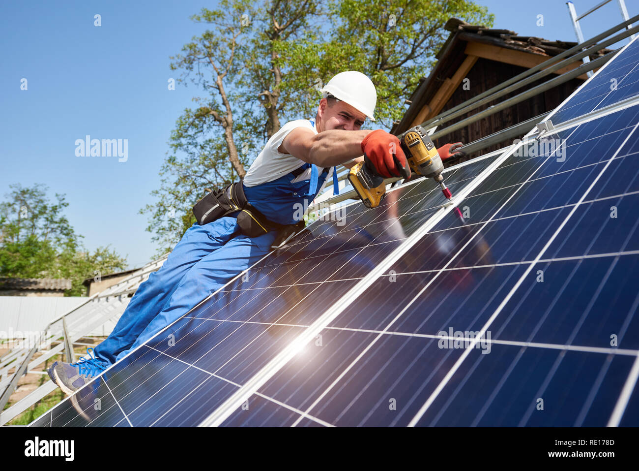 Technician installing solar photo voltaic panel to metal platform using