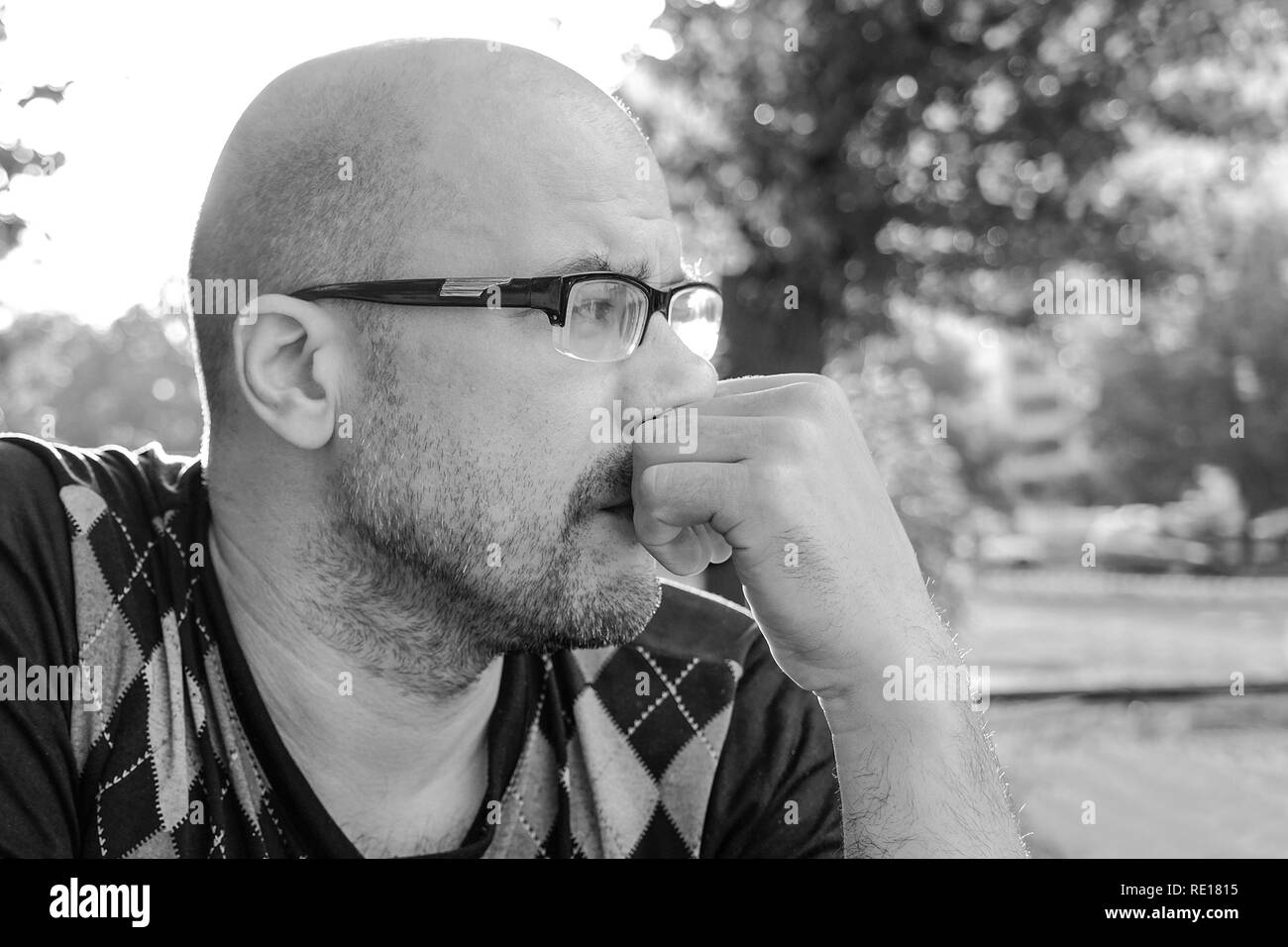 Black and white photo .The man with glasses is depressed . Problems in personal life and at work. Stress and depression. Migraine is a consequence of  Stock Photo