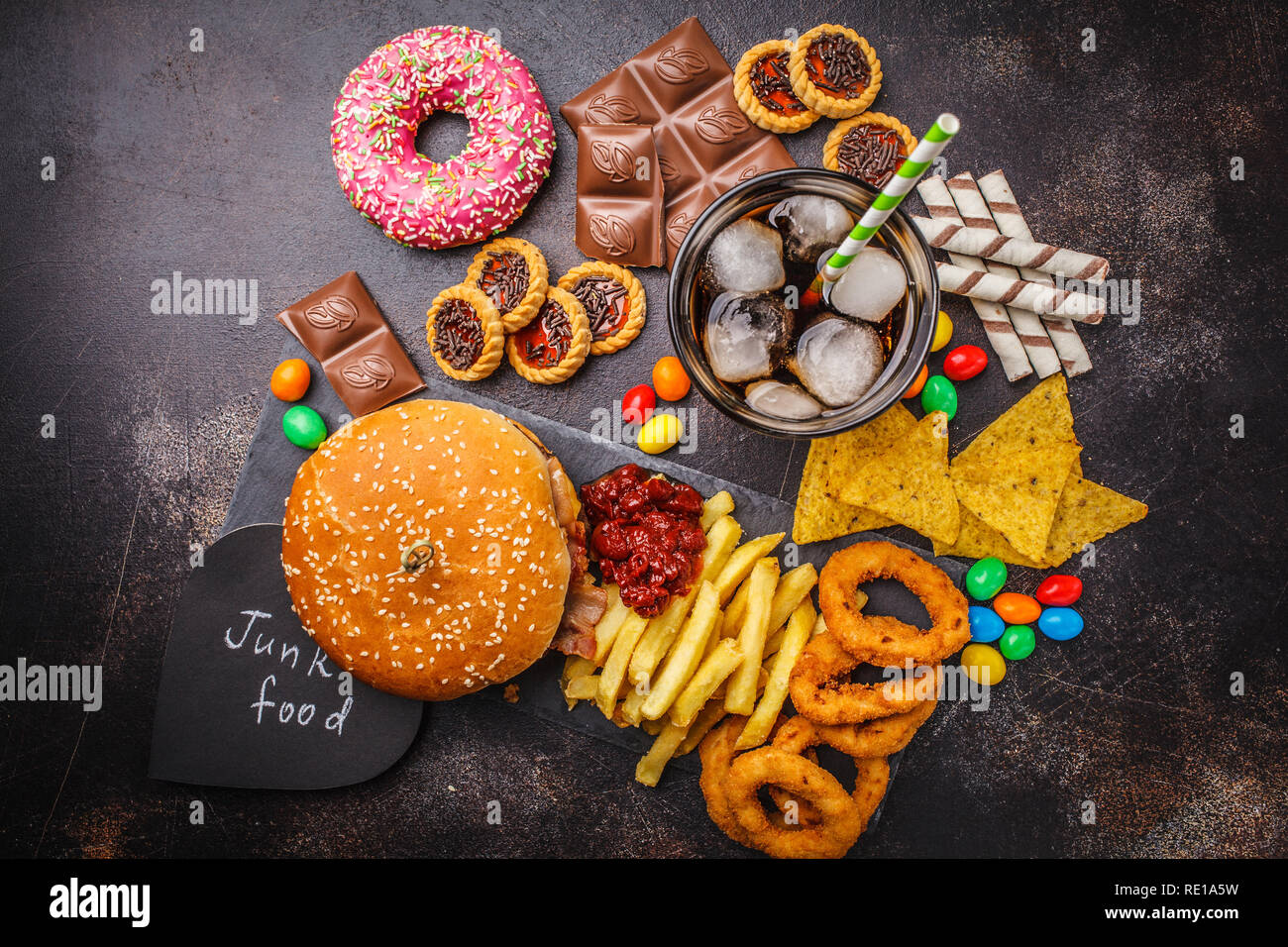 Junk food concept. Unhealthy food background. Fast food and sugar. Burger,  sweets, chips, chocolate, donuts, soda on a dark background Stock Photo -  Alamy