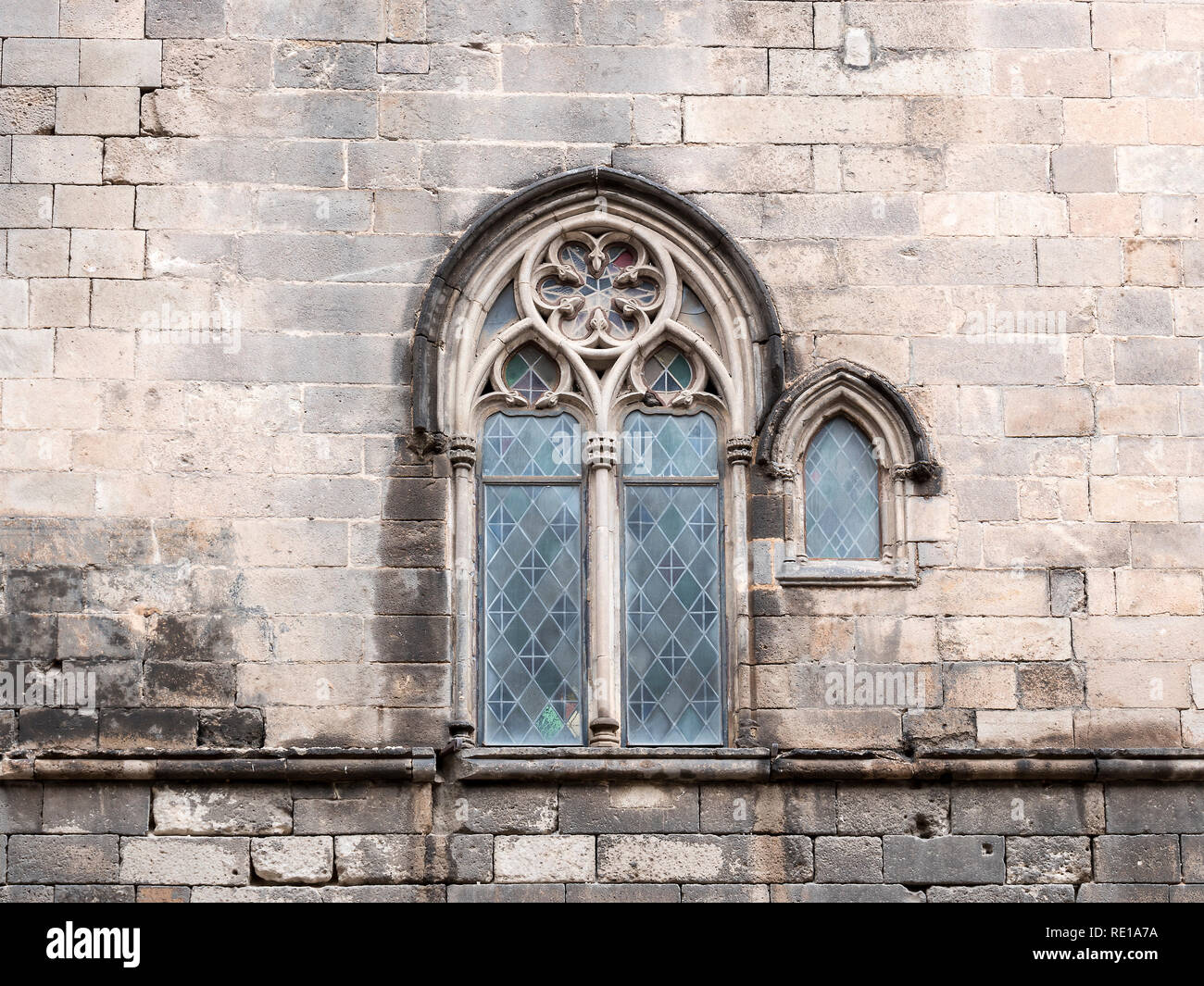 Traditional ancient gothic style window. Old vintage window on stone wall. Stock Photo