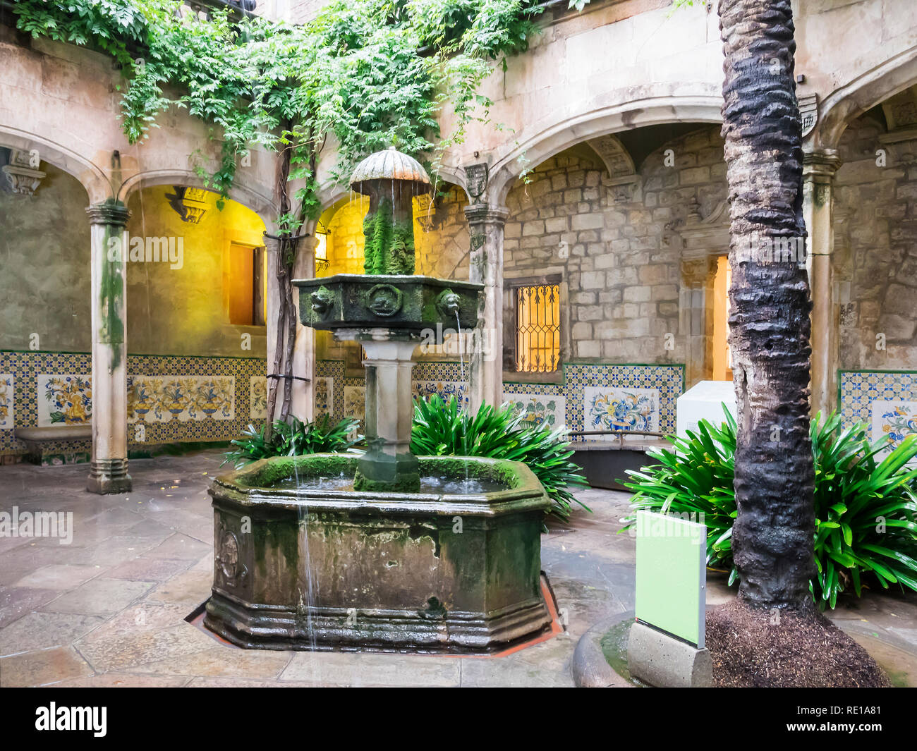 Barcelona, Spain, Nov 1, 2018: Typical spanish courtryard or patio with fountain and greenary. Beautiful archs and walls made of stone. No people. Stock Photo