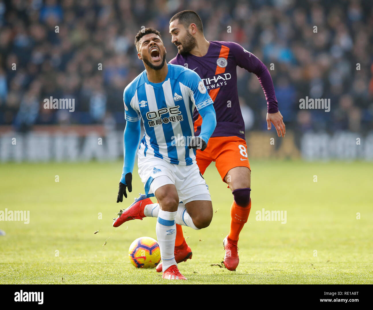 Huddersfield Town's Elias Kachunga (front) reacts in pain after a challenge bu Manchester City's Ilkay Gundogan during the Premier League match at The John Smith's Stadium, Huddersfield. Stock Photo