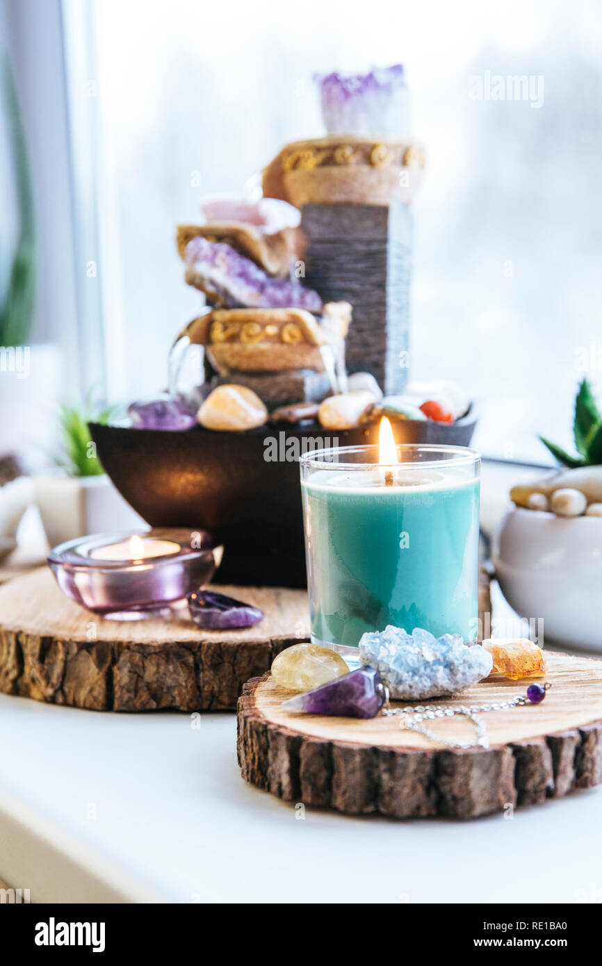 Relaxing spiritual Feng Shui altar set with nature, water and fire element. Tabletop small electrical fountain with water pouring cups. Symbol wealth. Stock Photo