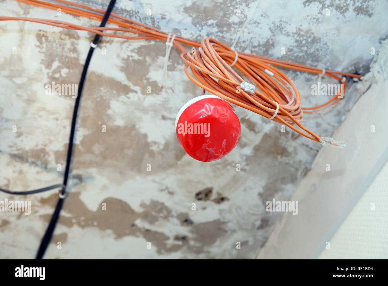 Closeup installation and repair of electric cable, smoke detector, fire alarm system before