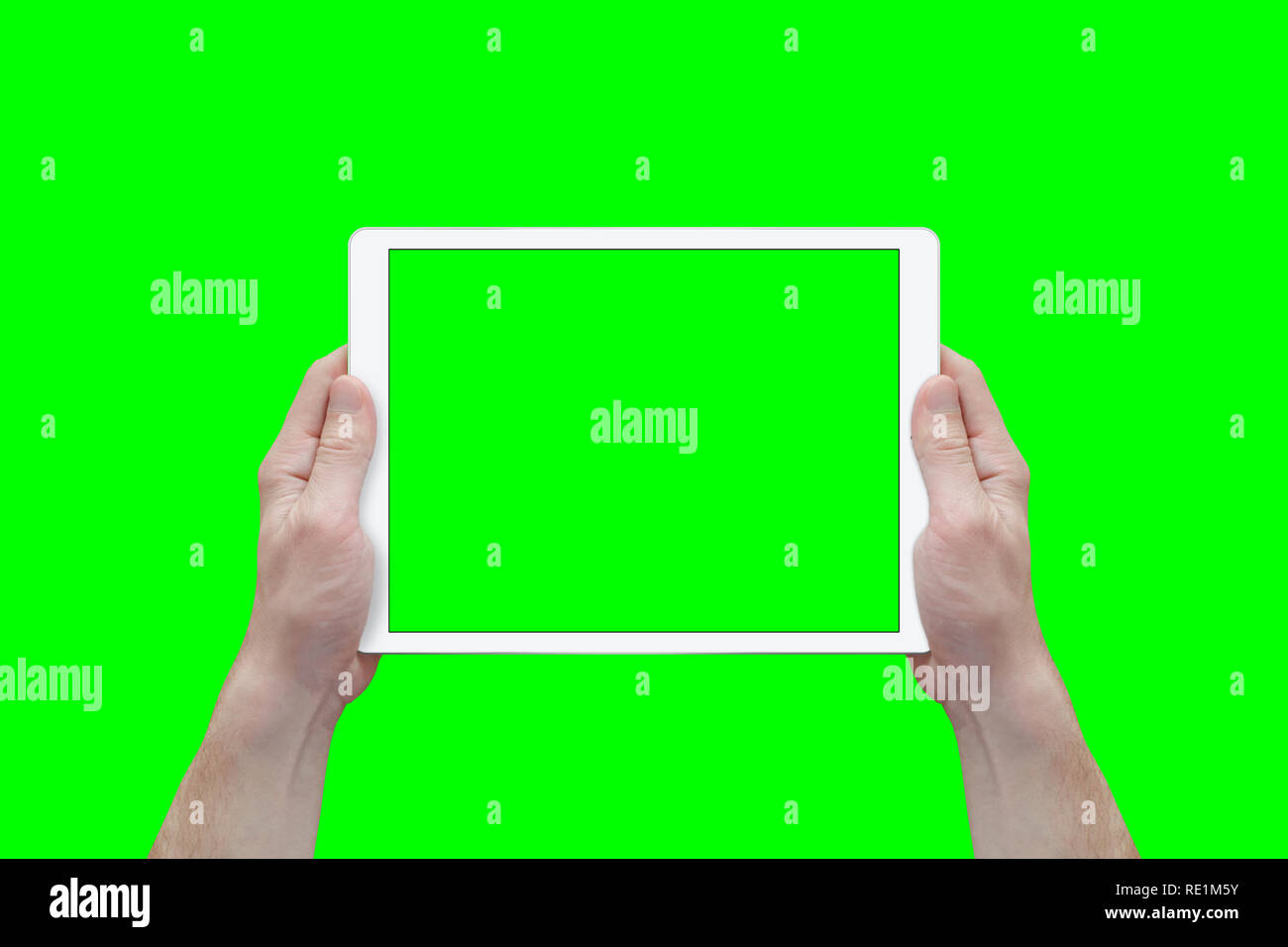 Hands hold white tablet in a horizontal position. View from first person. Isolated screen and background in green. Stock Photo