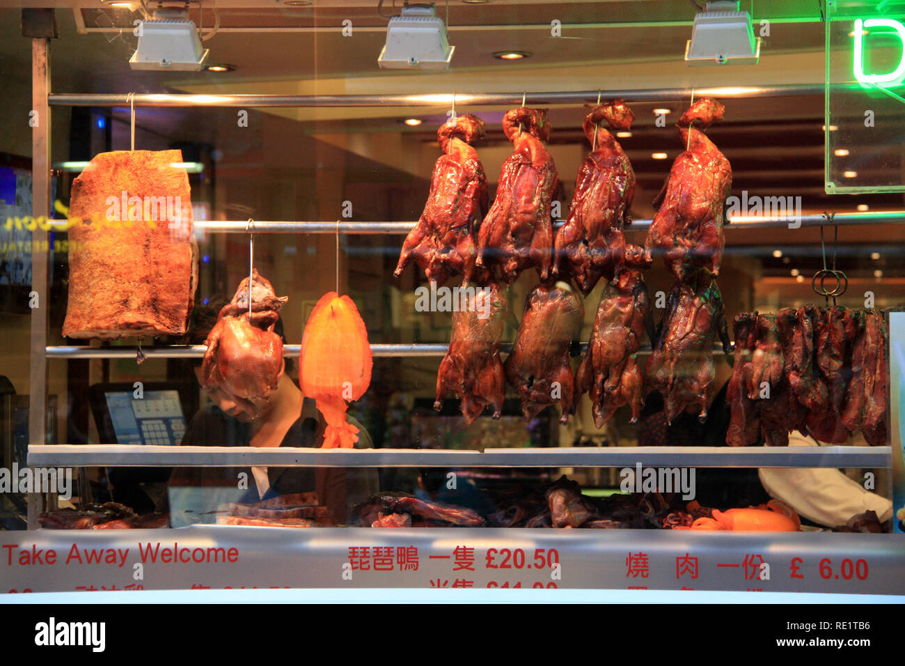 Roasted ducks, giant squid and other delicious Chinese food hanging in a store window in China Town in London, United Kingdom Stock Photo