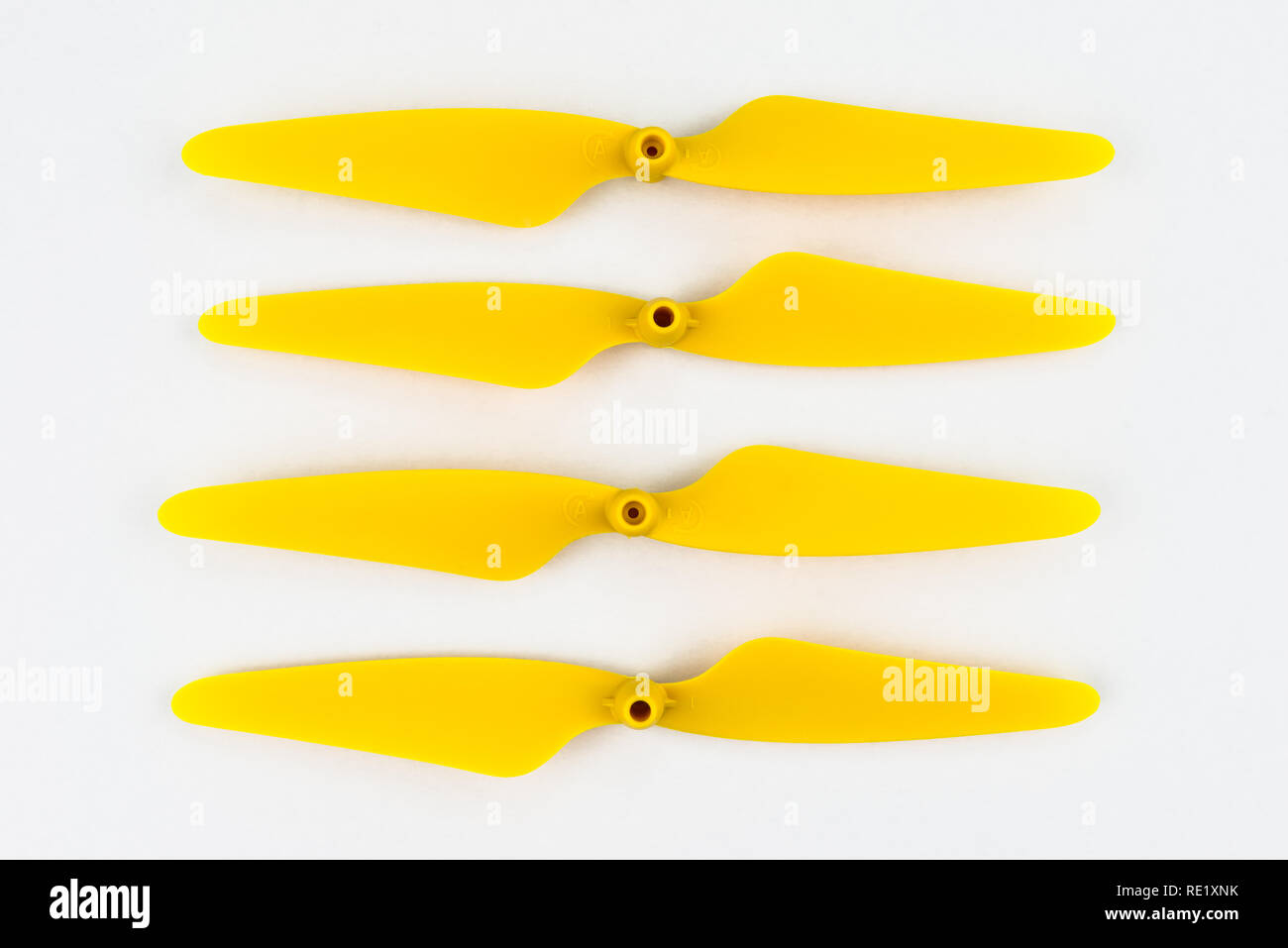 Yellow, plastic propellers for a quadcopter drone, isolated on white background with clipping path. Four pieces arranged in a row. Stock Photo