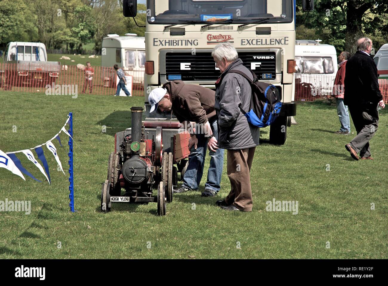 Two men scrutinise a miniature steam traction engine at the Anglesey Vintage Rally, Anglesey, North Wales, UK, May 2010 Stock Photo