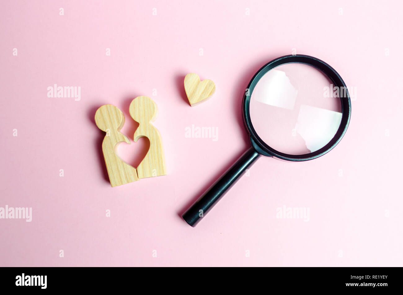 A young pair of lovers and a magnifying glass. Search for love and creation of strong love relationships. Dating and flirt, search for a love partner. Stock Photo