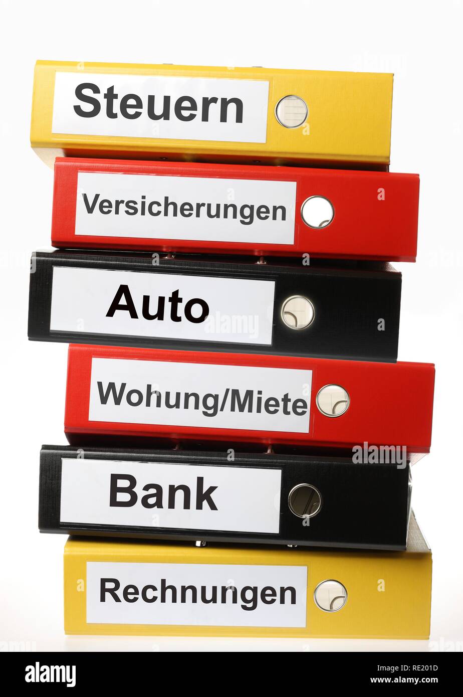 Black, yellow and red ring binders, labelled in German for taxes, insurance, car, apartment, rent, bank accounts, invoices Stock Photo