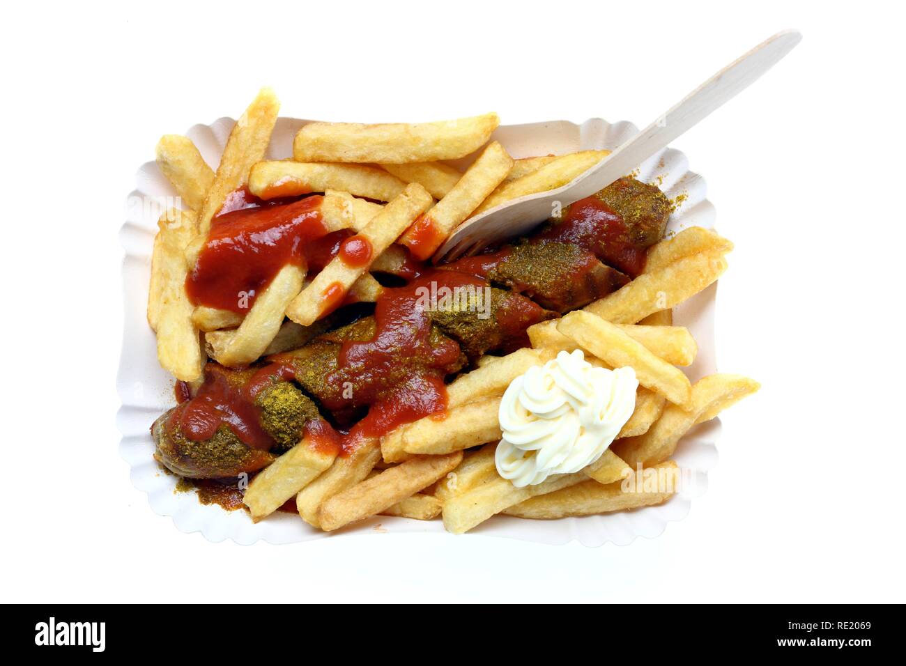 Currywurst with chips, mayonnaise and curry sauce on a paper plate, hot