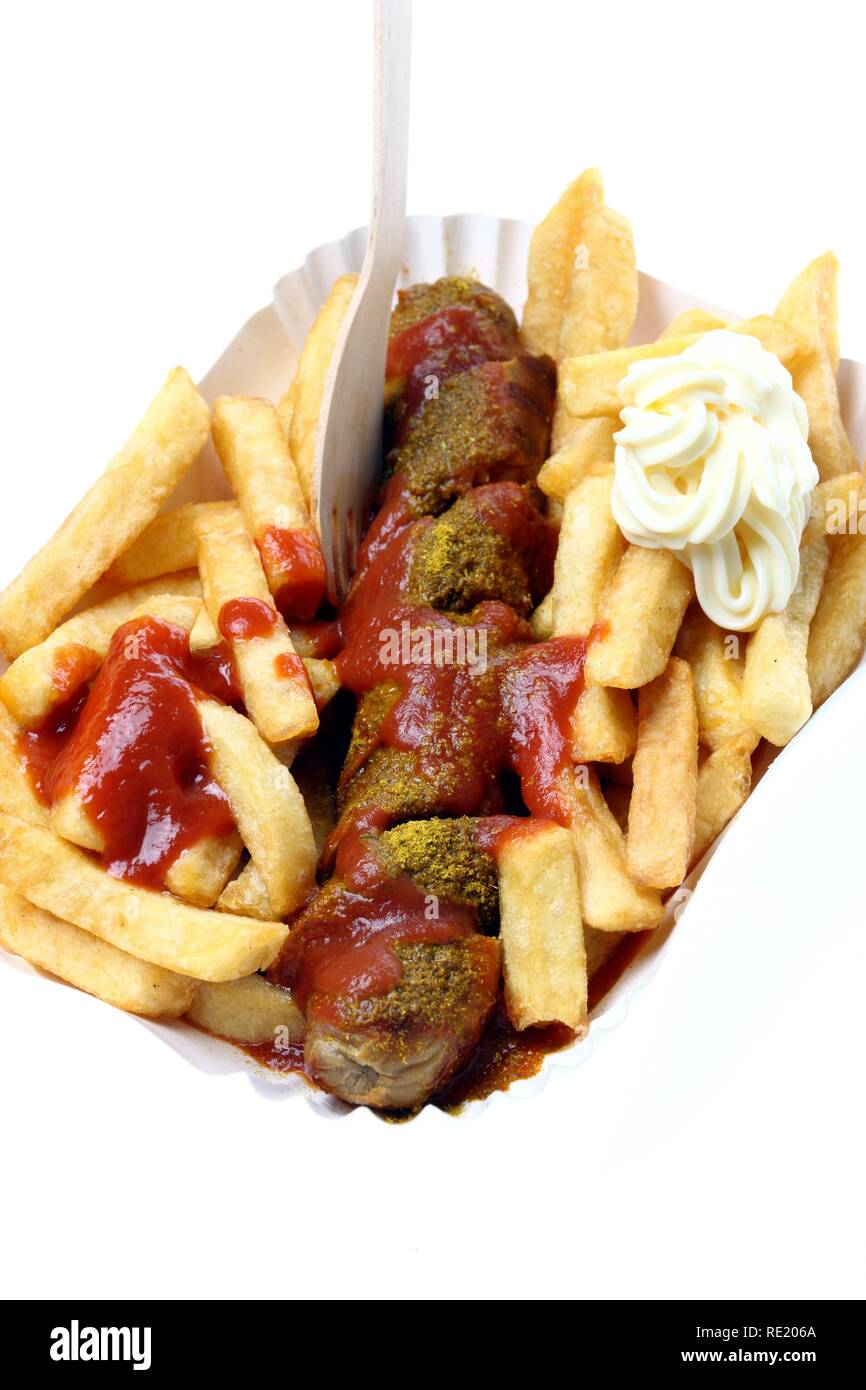 Currywurst with chips, mayonnaise and curry sauce on a paper plate, hot pork sausage Stock Photo