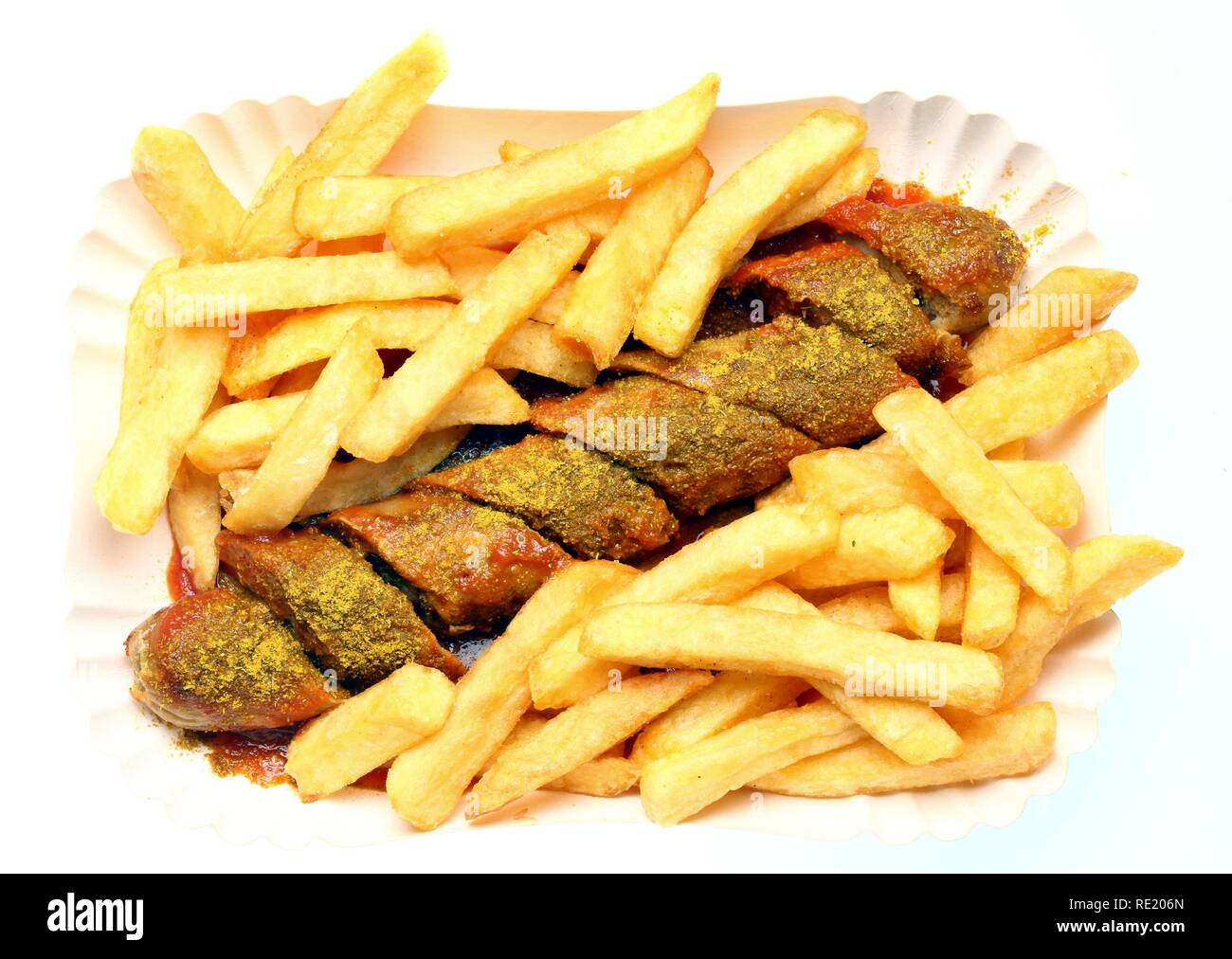 Currywurst with chips and curry sauce on a paper plate, hot pork