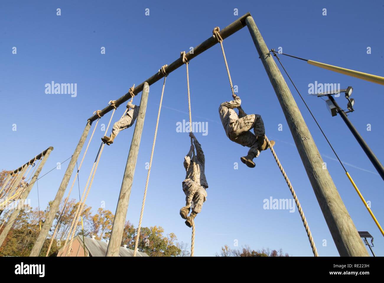 U.S. Marine candidates with Officer Candidate School (OCS) climb up a rope during the Obstacle