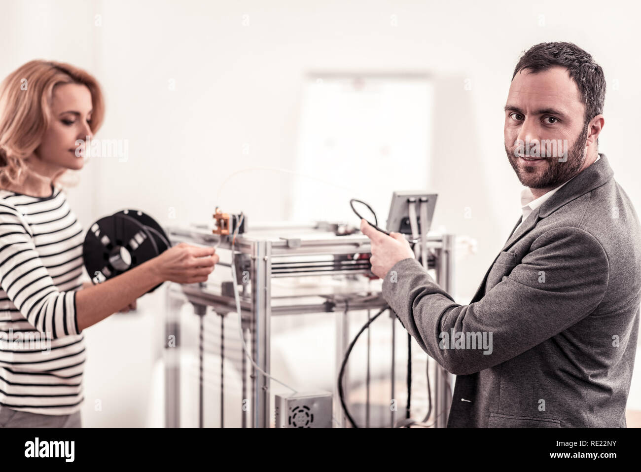 Intelligent technicians fixing and adjusting office equipment Stock Photo