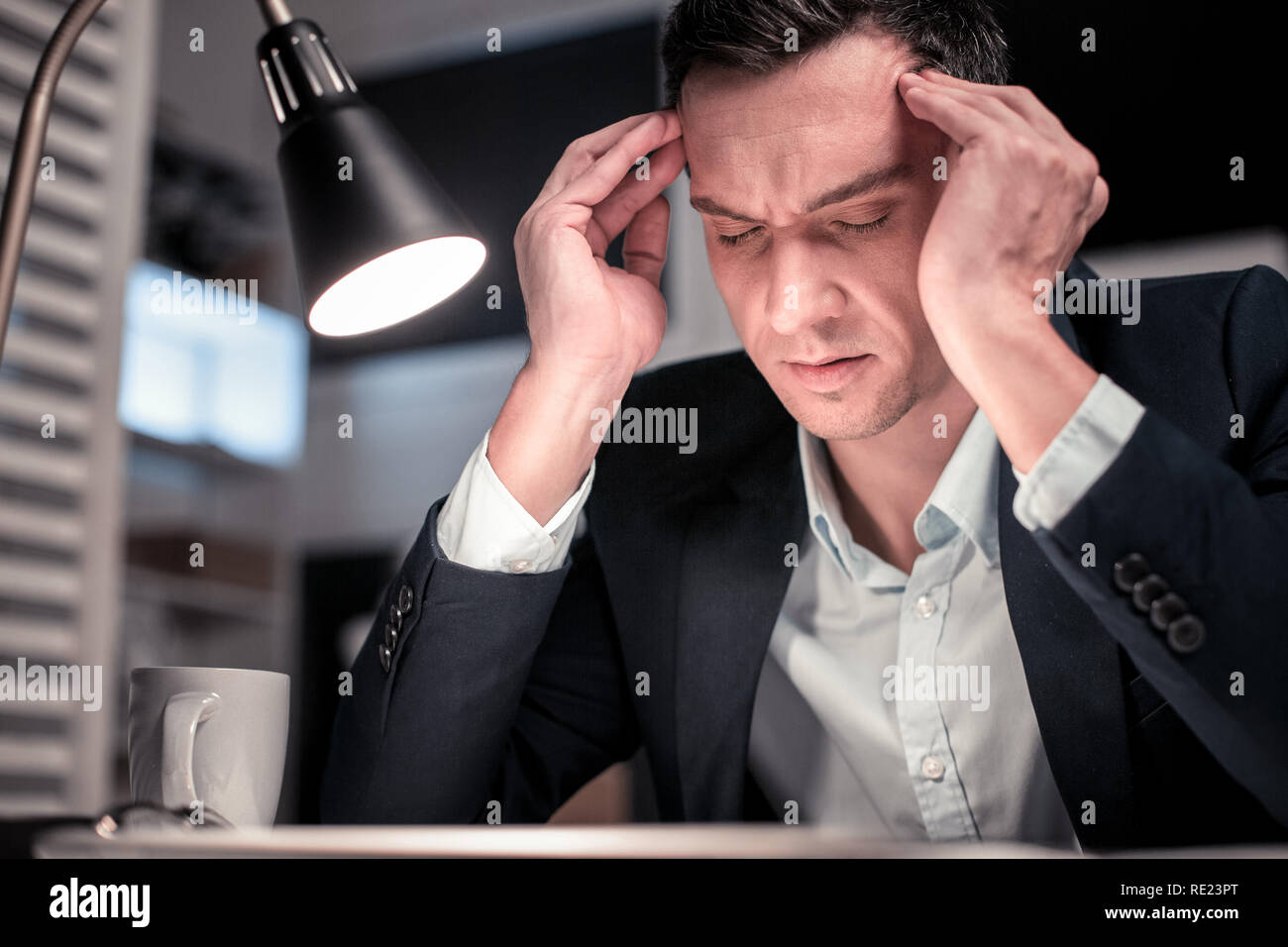 Smart nice tired man touching his temples Stock Photo