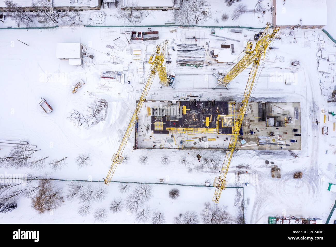 yellow tower cranes working at city construction site in winter under ...