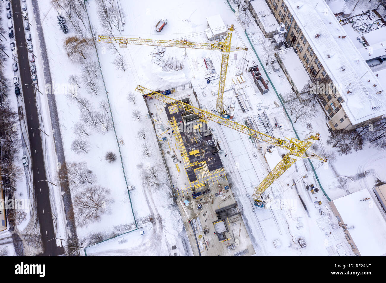 aerial top view of construction site in winter. yellow tower cranes ...
