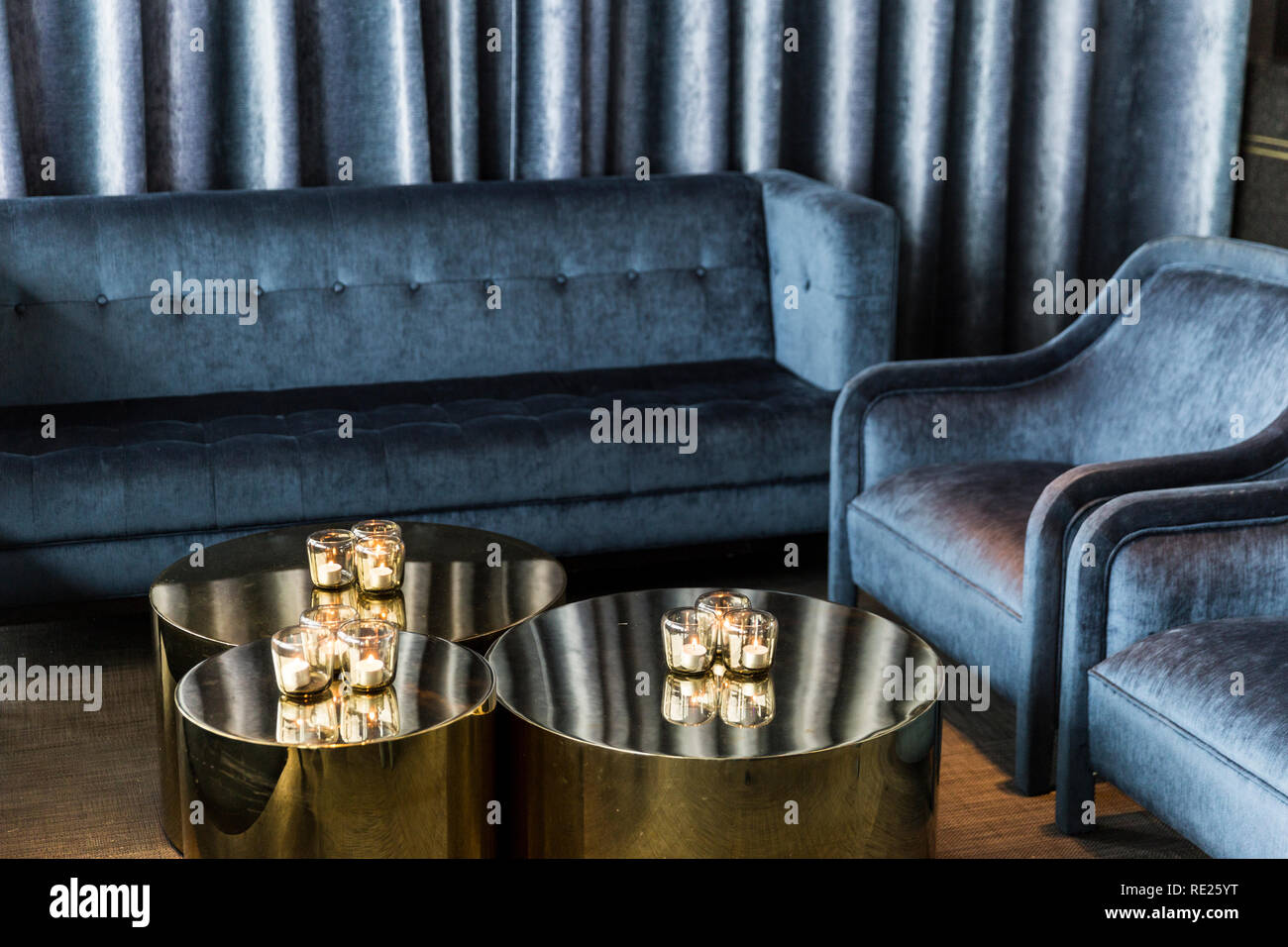 Luxurious blue couch setting with candles to set the perfect ambience
