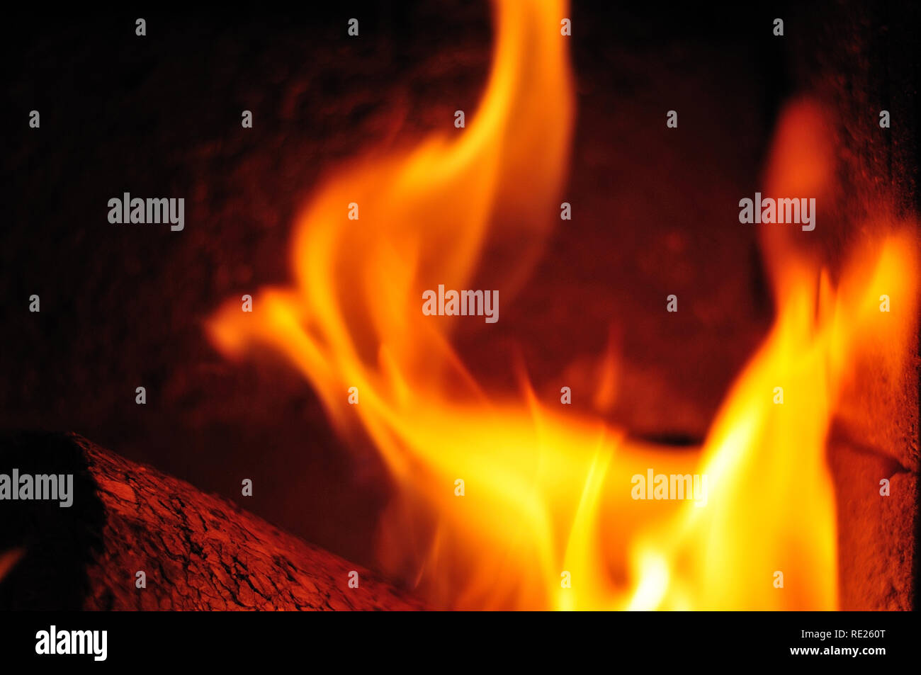 Wooden Briquet Burning In Fireplace With Chamotte Stones Stock