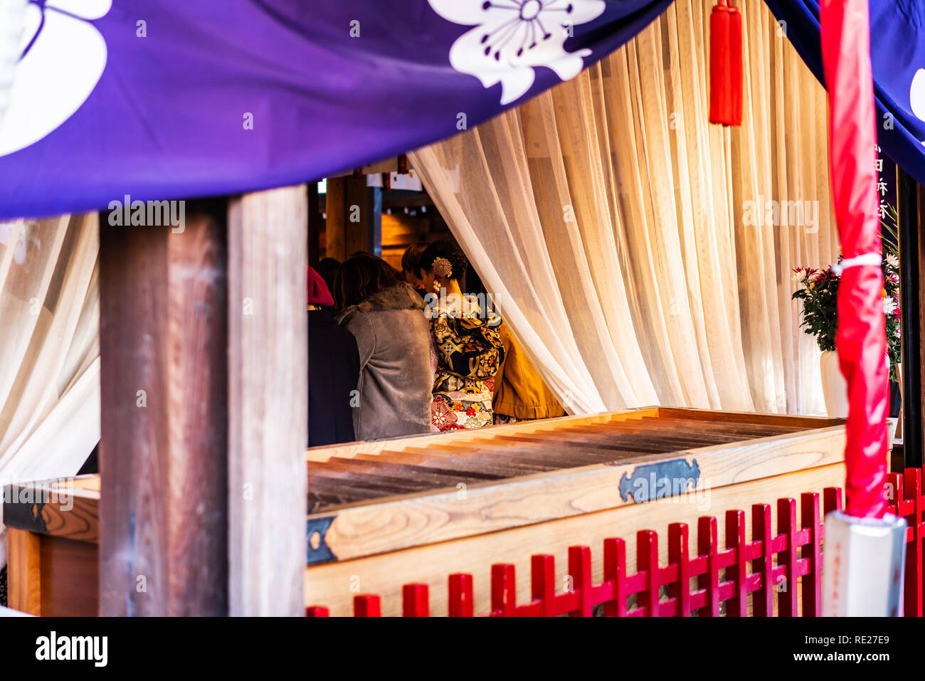 Asia culture concept - woman with kimono pray under shimenawa rope of traditional kushida shrine in Fukuoka Japan Stock Photo