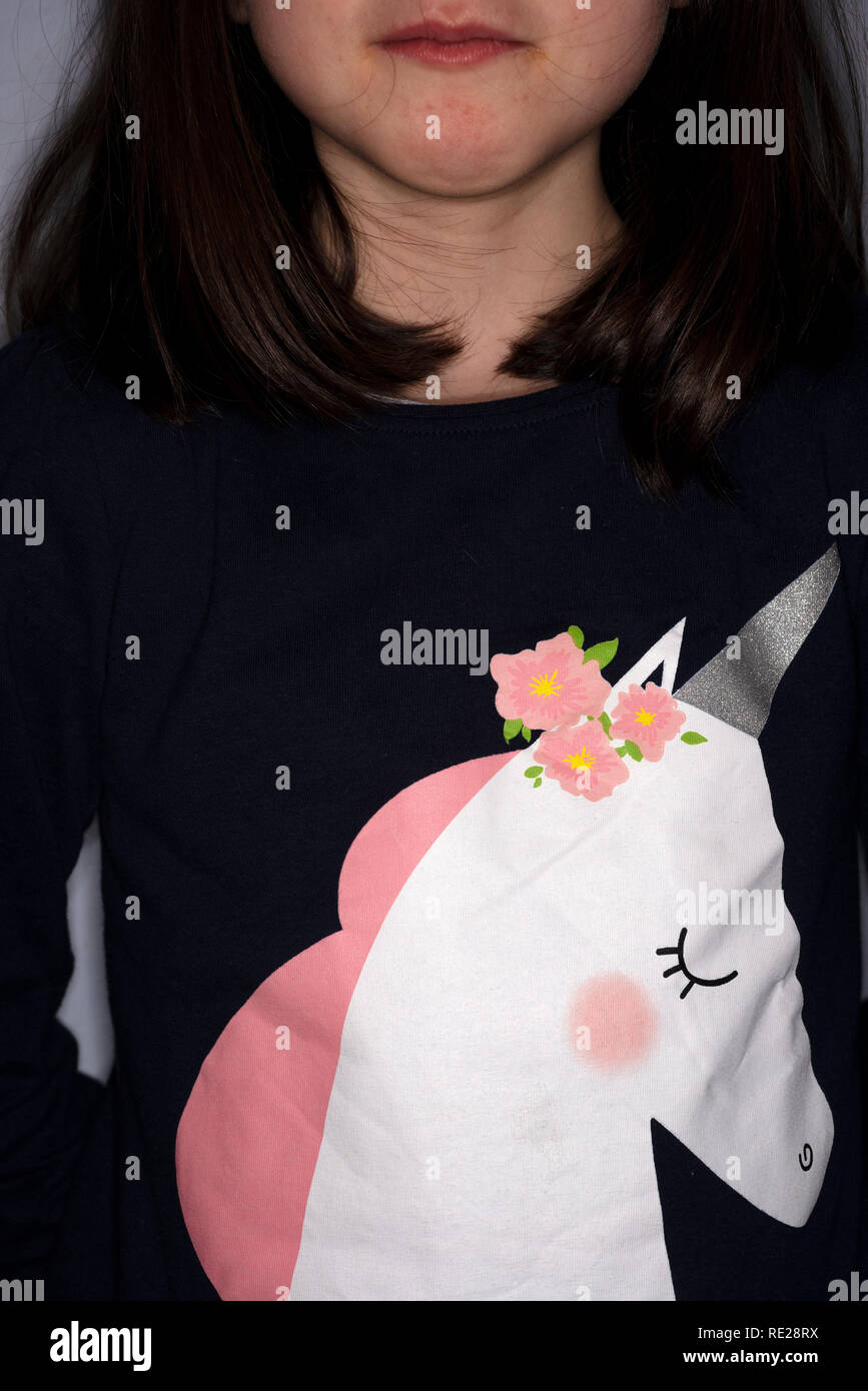 Young girl wearing a unicorn jumper hires stock photography and images