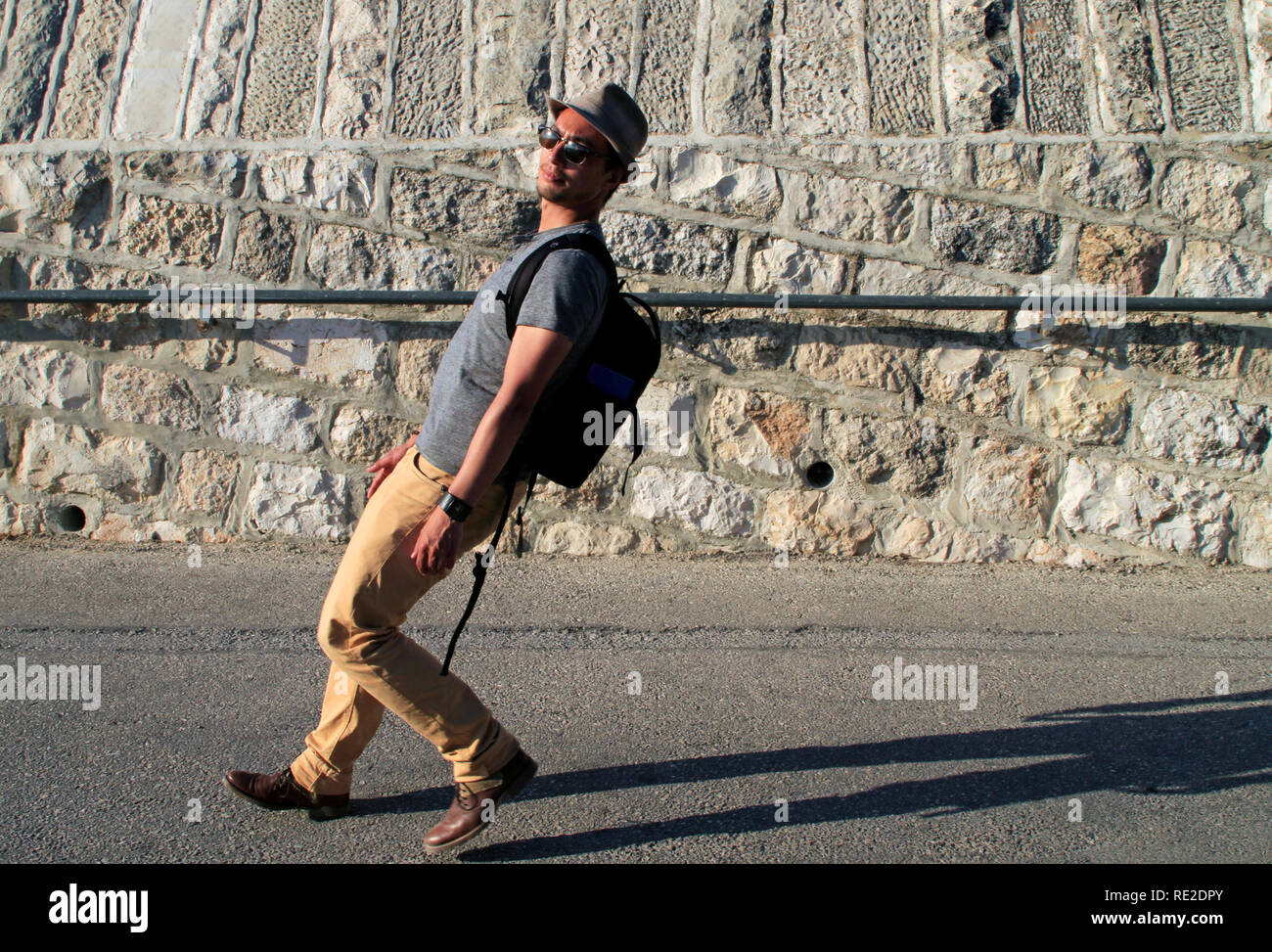 Man walking down a steep road in a funny angle Stock Photo