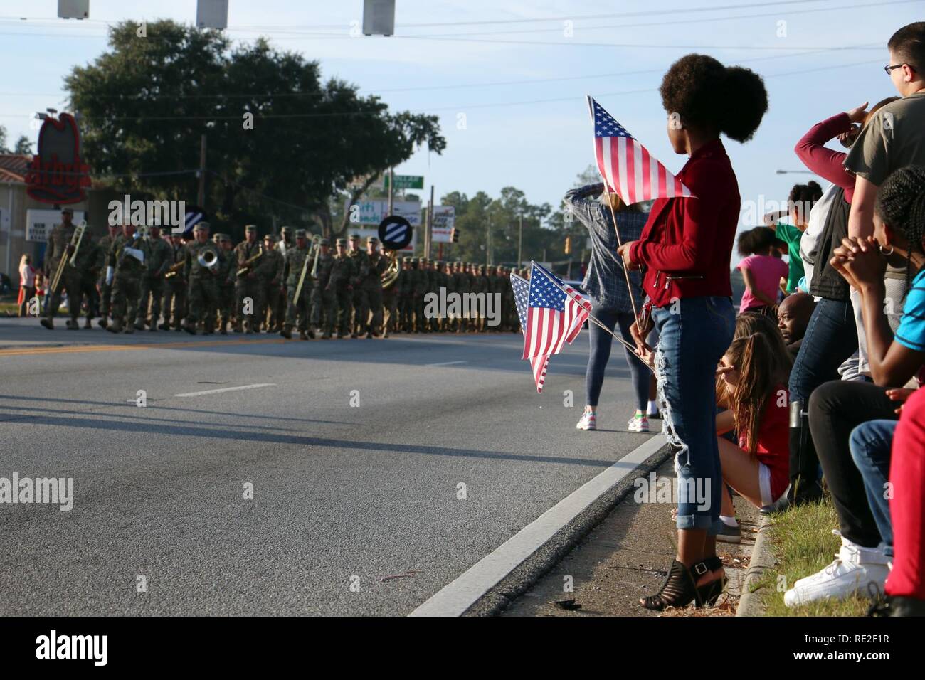 Spectators wave American flags as Soldiers of 3rd Infantry Division