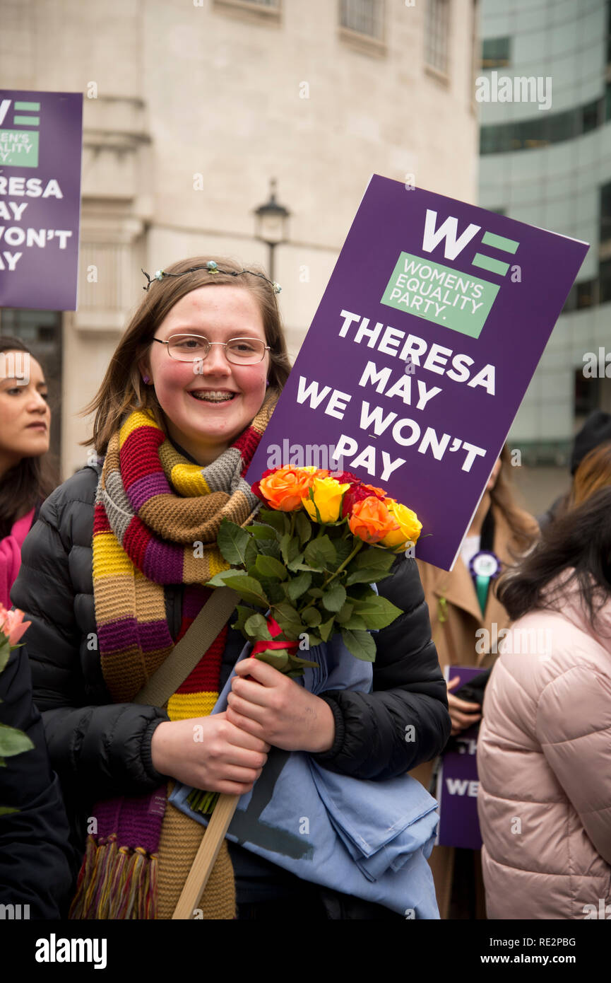 London, UK. January 19th 2019. London Women's march, part of a worldwide protest at violence against women and the effects of austerity. A young woman holds a bunch of flowers and a placard from the Women's Equality Party saying 'Theresa May we wont pay'. Credit: Jenny Matthews/Alamy Live News Stock Photo