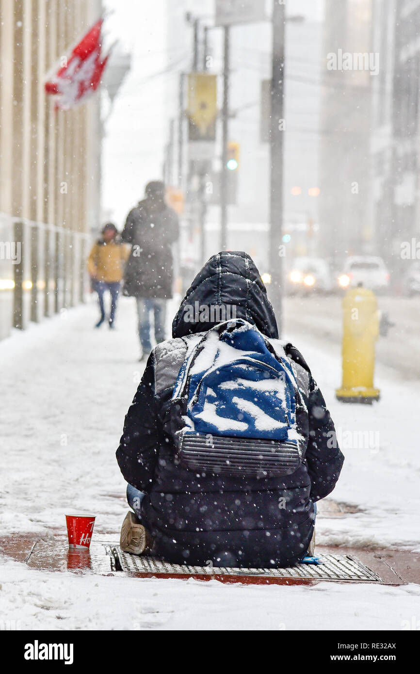 Toronto, Canada. 19th Jan 2019. Toronto's homeless stay warm by seating on  top of subway exhaust vent during Toronto's first major winter storm  accompanied with an extreme cold temperature alert. Dominic Chan/EXimages
