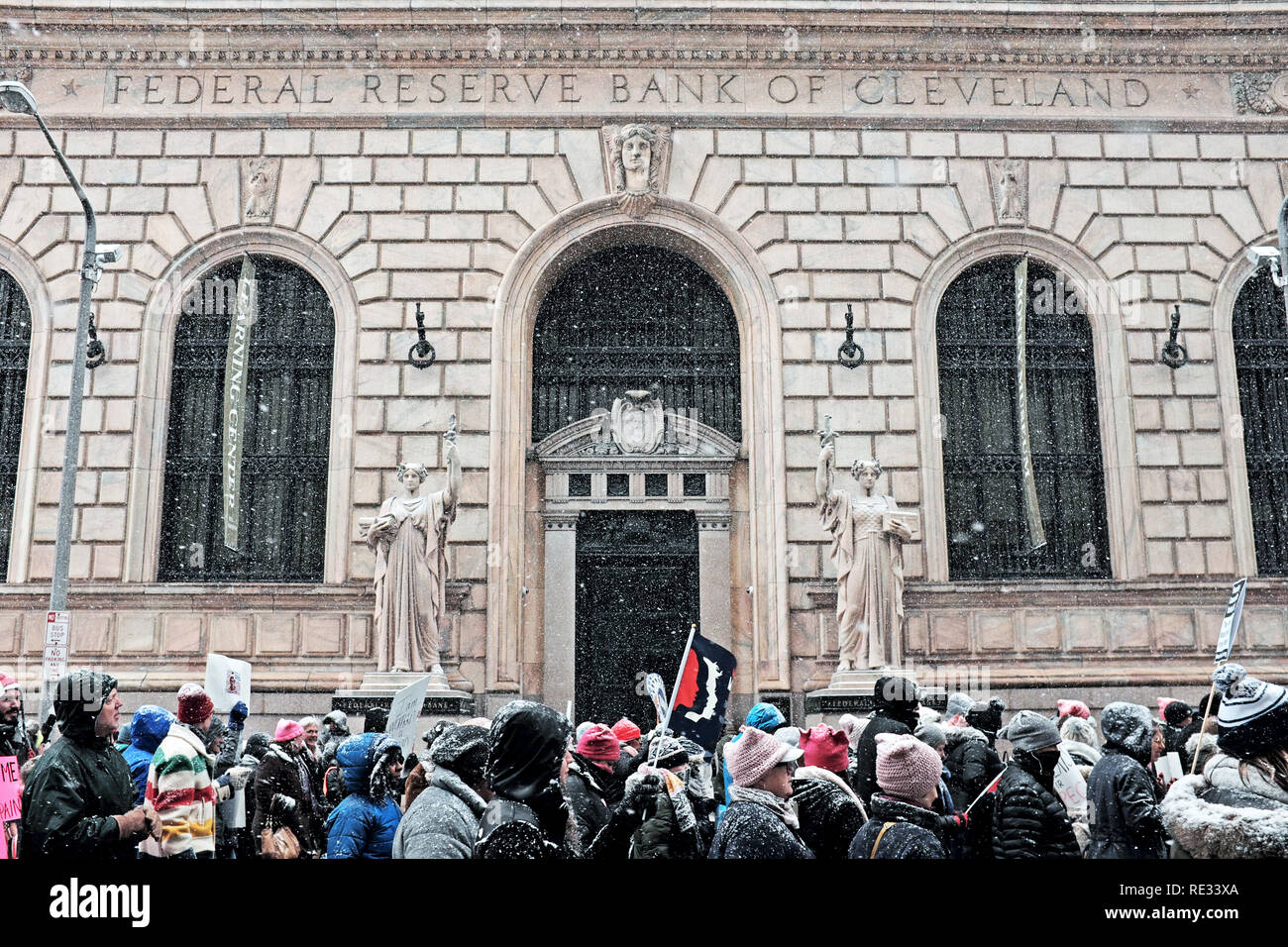 Cleveland, Ohio, USA, 19th January, 2019.  Winter storm Harper, the first major winter storm of the season starts to blanket participants in the 2019 Women's March in downtown Cleveland, Ohio, USA as they pass the Federal Reserve Bank of Cleveland.  Credit: Mark Kanning/Alamy Live News. Stock Photo