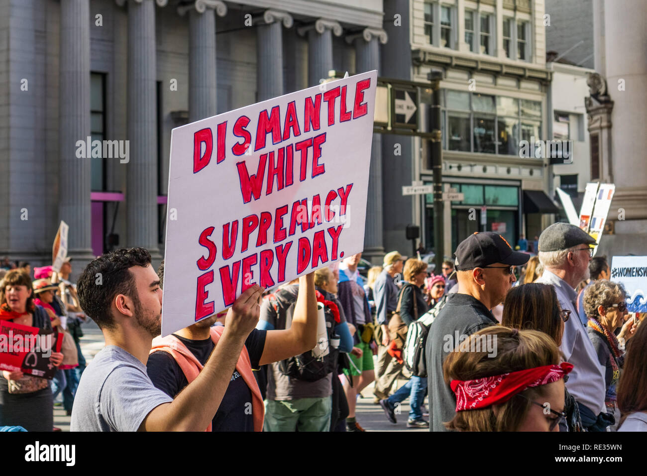 San Francisco, USA. 19th Jan 2019.  Participant to the Women's March event holds 'Dismantle white supremacy everyday' sign while marching on Market street in downtown San Francisco Stock Photo