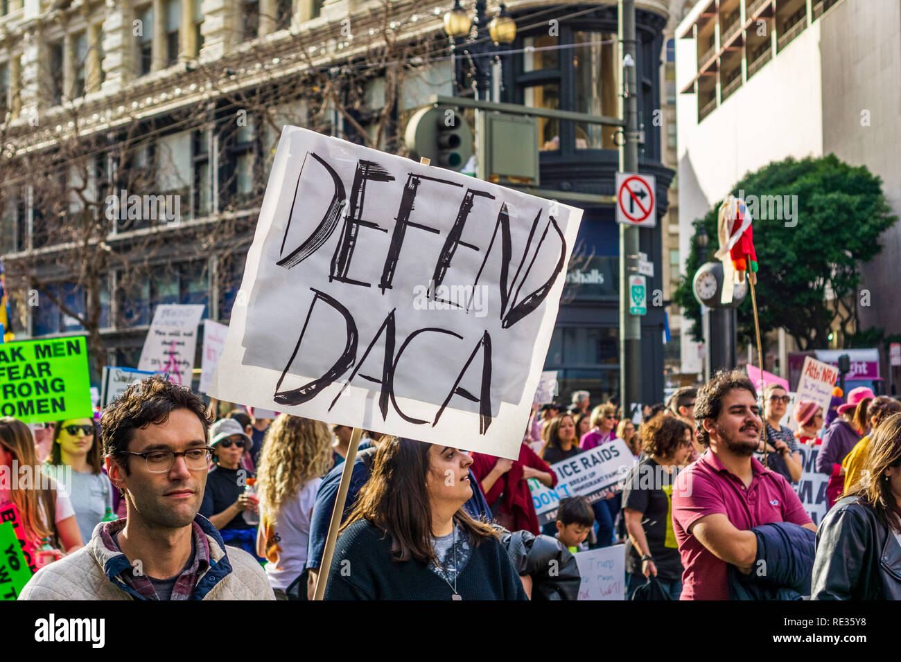 San Francisco, USA. 19th Jan 2019.  Participant to the Women's March event holds 'Defend DACA' sign while marching on Market street in downtown San Francisco Stock Photo