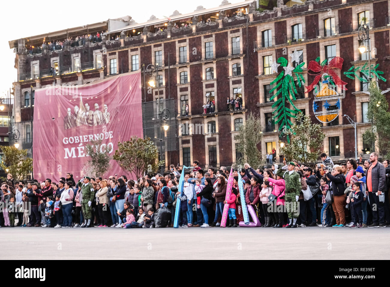 Military police cadre taking down Mexico national flag at Zocalo, Mexico City, with people watching Stock Photo