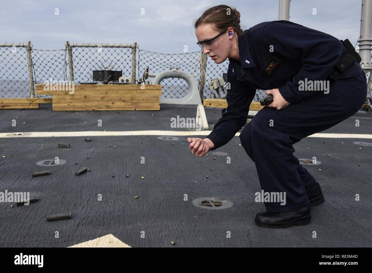 EDITERRANEAN SEA (Nov. 14, 2016) Lt. j.g Danielle Garbarino from Vail, Colo., polices her brass during a small arms shoot aboard USS Ross (DDG 71) Nov. 14, 2016.  Ross, an Arleigh Burke-class guided-missile destroyer, forward-deployed to Rota, Spain, is conducting naval operations in the U.S. 6th Fleet area of operations in support of U.S. national security interests in Europe and Africa. Stock Photo