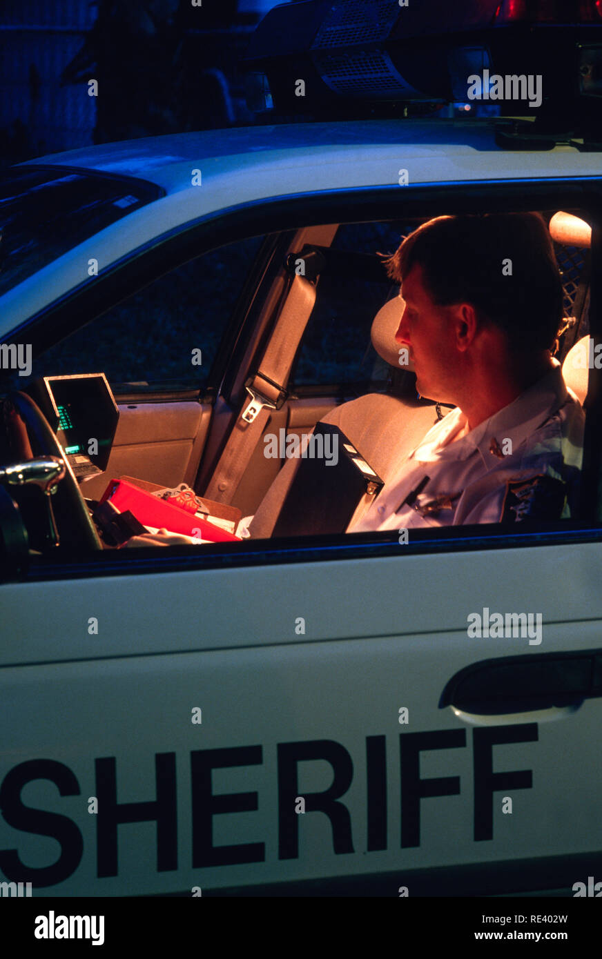 Police Officer Works the night shift in his car, 1996, in Florida, USA Stock Photo