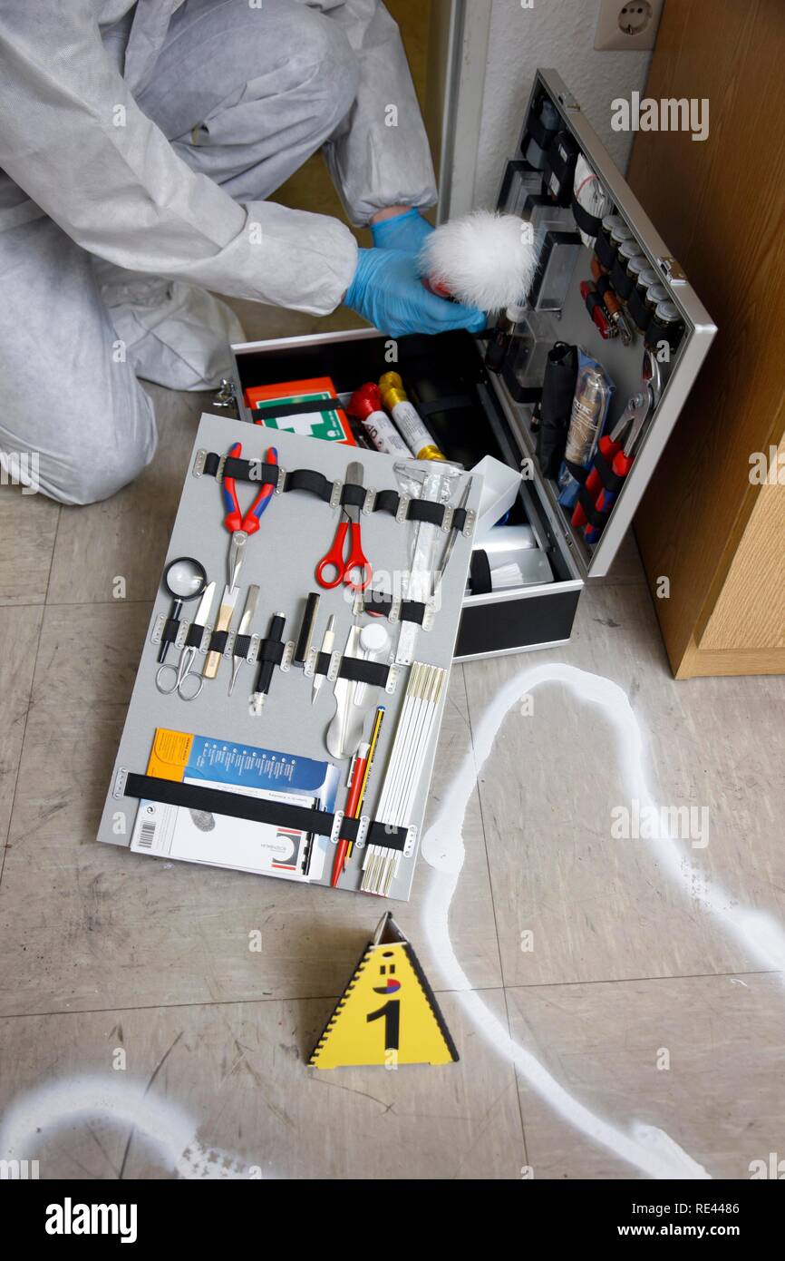 Forensic's case, officer of the C.I.D., the Criminal Investigation Department, gathering forensic evidence at the scene of a Stock Photo