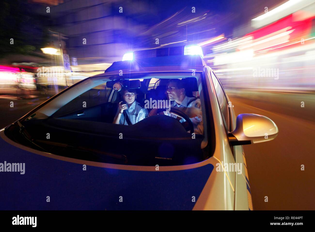 Police patrol car driving with flashing lights and sirens Stock Photo