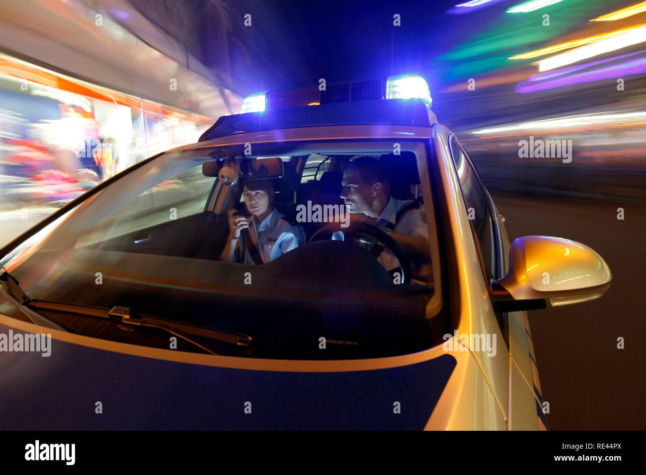 Police patrol car driving with flashing lights and sirens Stock Photo