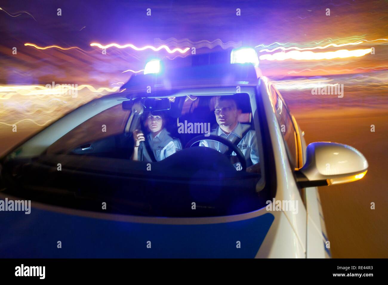 Police patrol car driving with flashing lights and sirens Stock Photo